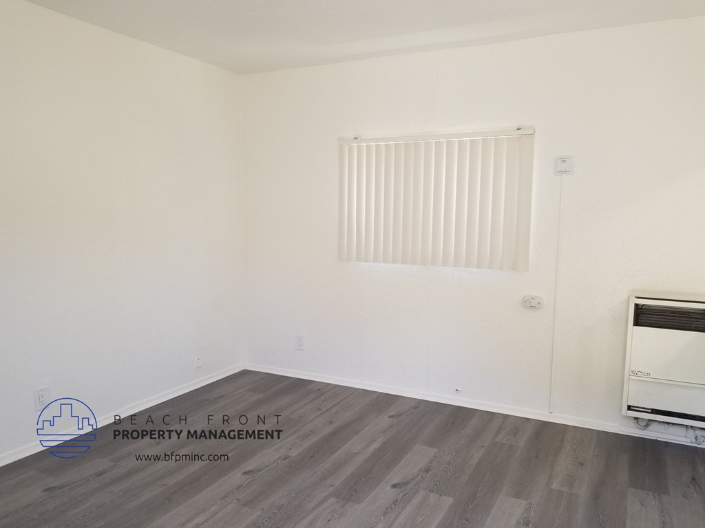 an empty room with a radiator and a window